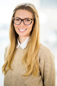 Headshot of Kristen Engfors-Boess, a woman with long, straight blonde hair and tortoiseshell glasses wearing a beige sweater with a white collar showing underneath